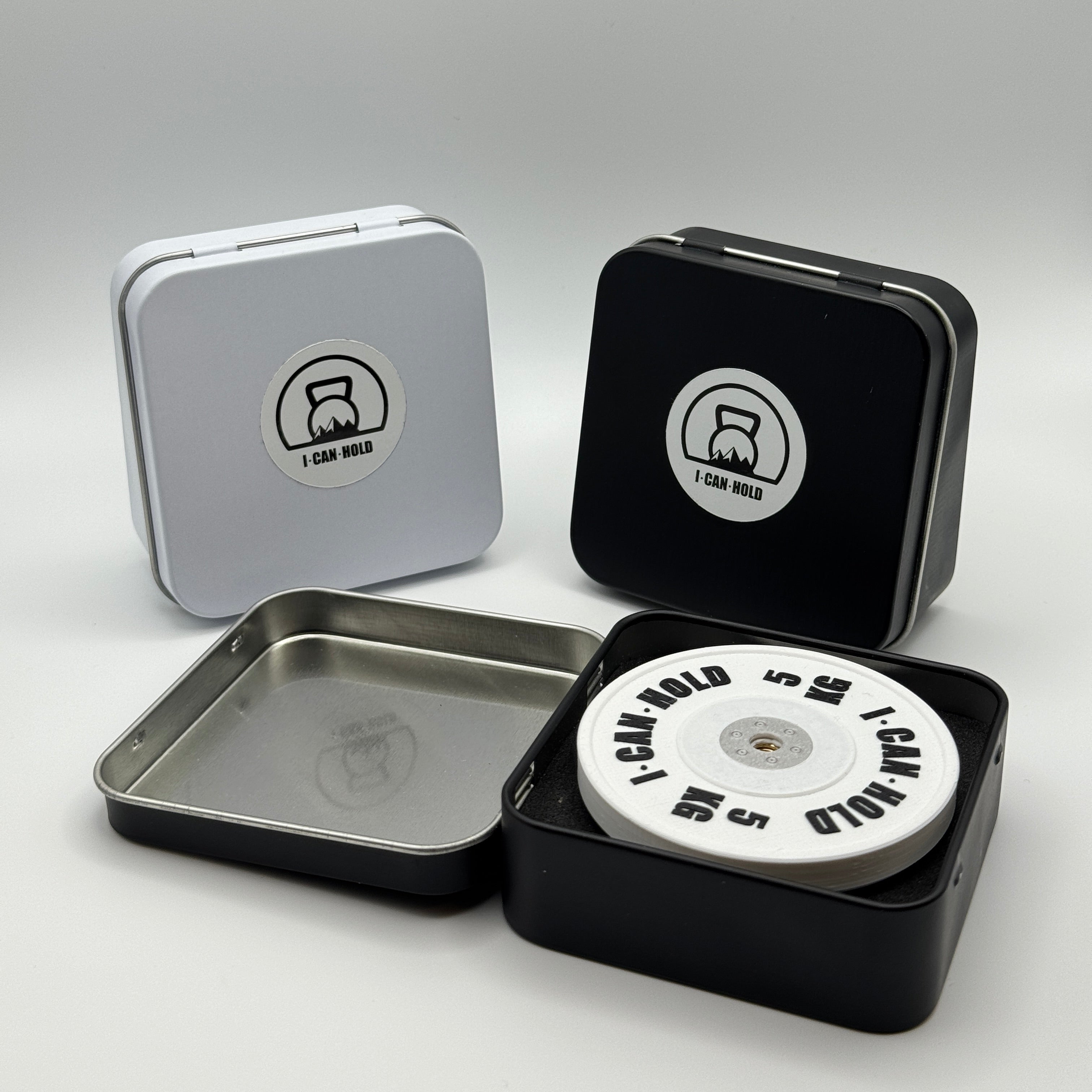 I•CAN•HOLD 5kg White Edition, die MagSafe Handyhalterung für's Gym drapiert mit drei metallischen Aufbewahrungsboxen in weiß und schwarz